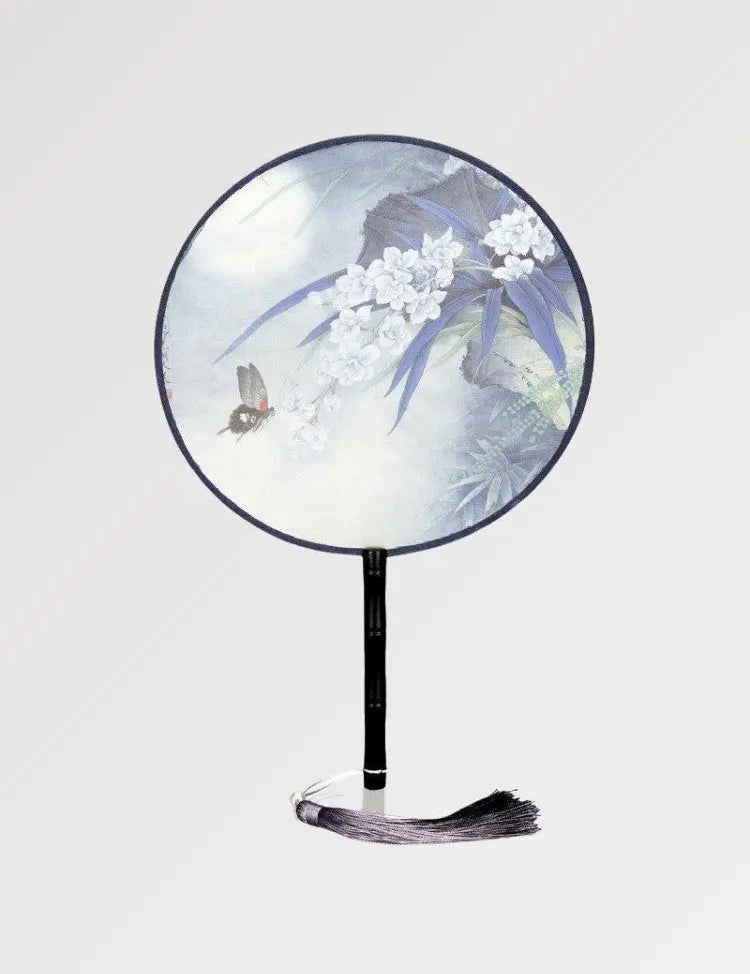 Un éventail japonais rond au motif fleuri et aux couleurs pastels