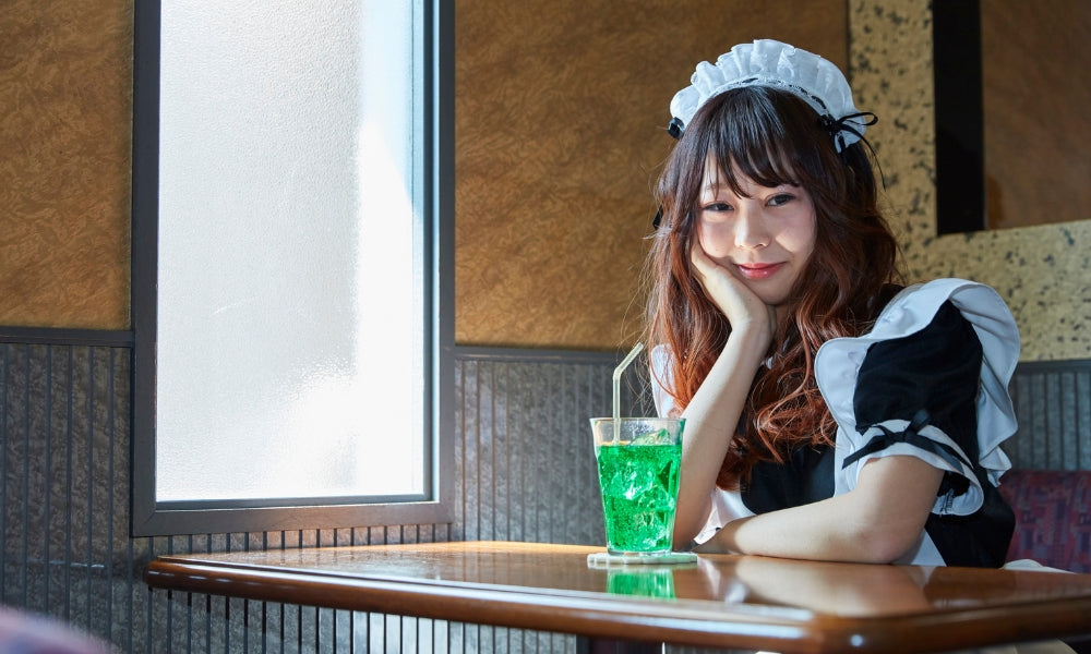 Serveuse en tenue de maid à une table dans un maid café japonais d'Akihabara
