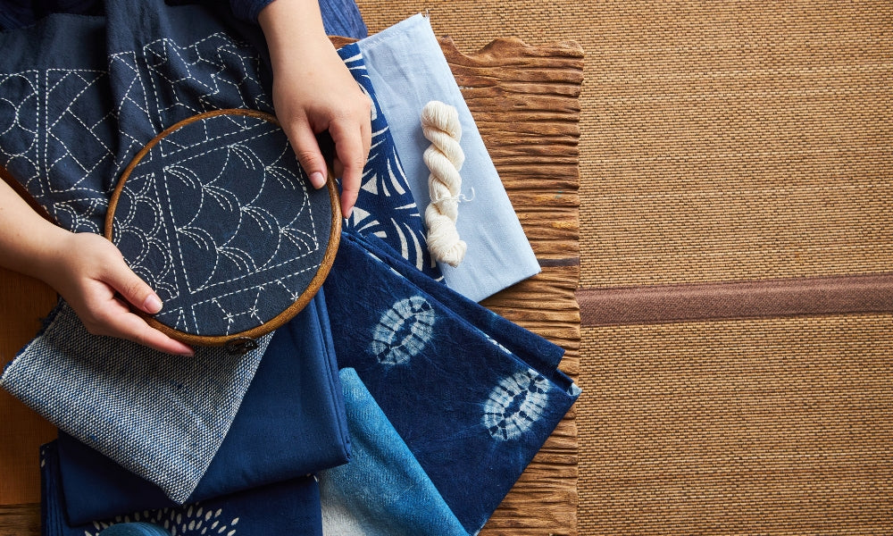 Couture sashiko japonaise : fil de coton blanc en motifs géométriques sur toile de coton indigo, l'art traditionnel du raccommodage japonais