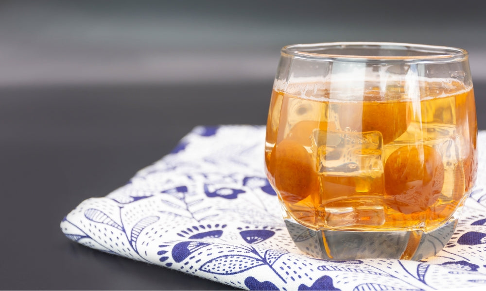 Umeshu, la liqueur de prune japonaise servie sur glace avec un fruit ume — boisson aigre-douce traditionnelle des foyers japonais