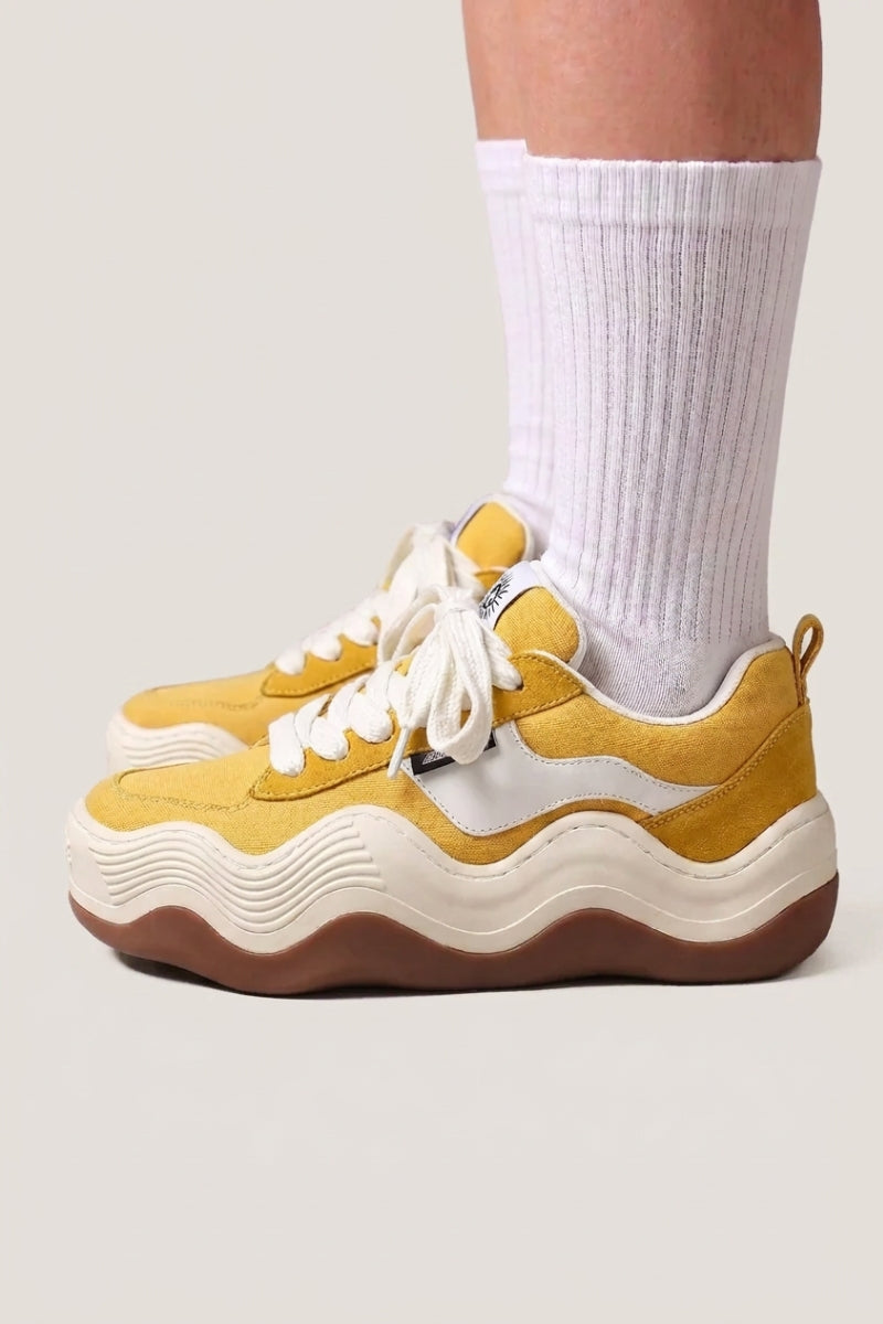 Collection baskets japonaises : baskets à plateforme en toile jaune, semelle crème ondulée, portées avec des chaussettes blanches