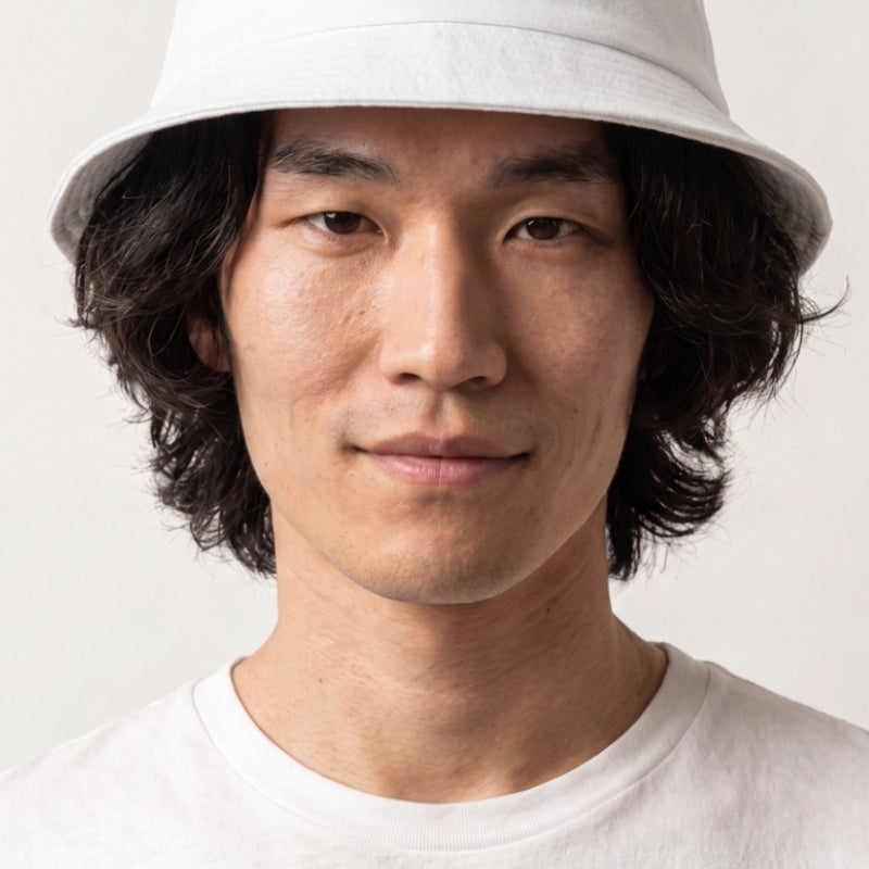 Collection bobs streetwear : homme portant un bob en coton blanc brodé d'un bol de ramen et de baguettes, esprit streetwear japonais