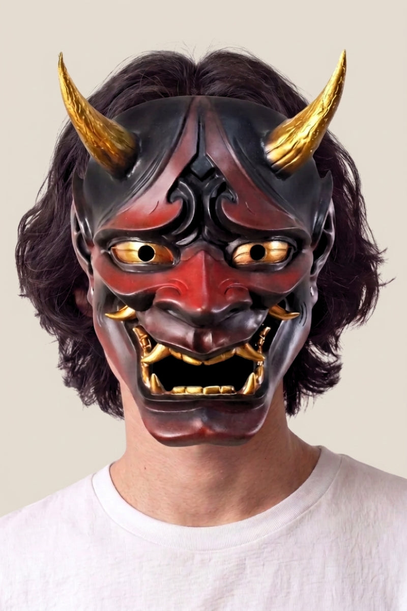 Collection masques japonais : homme portant un masque de démon hannya rouge et noir, cornes dorées, dents et yeux rehaussés d'or
