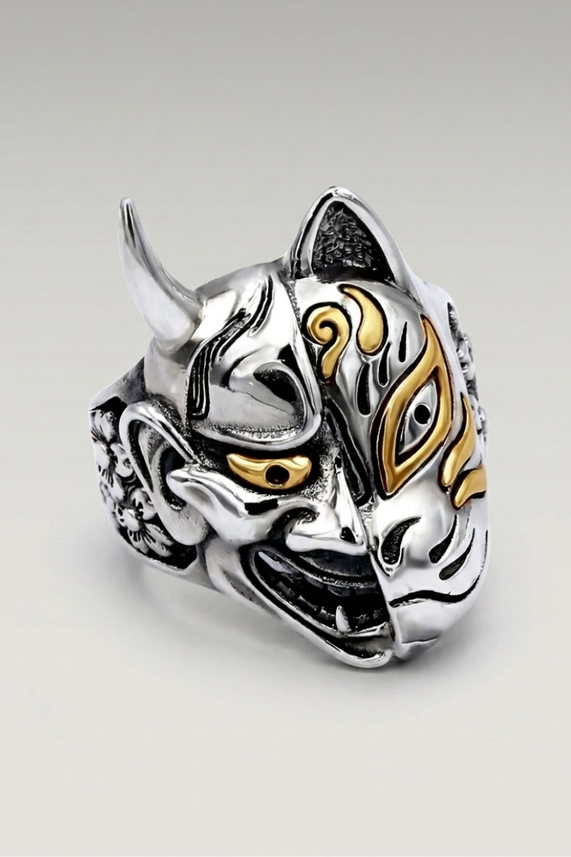 Bague Yokai Demon — chevalière sculptée en masque de démon aux cornes recourbées, œil rehaussé de doré, photo produit sur fond gris clair
