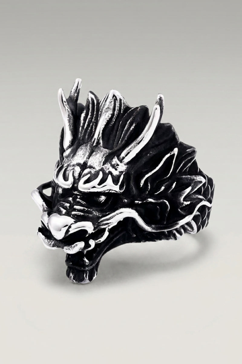 Bague 'Sephiro' — tête de dragon en acier, gueule ouverte, écailles et crocs détaillés, photo produit sur fond gris clair