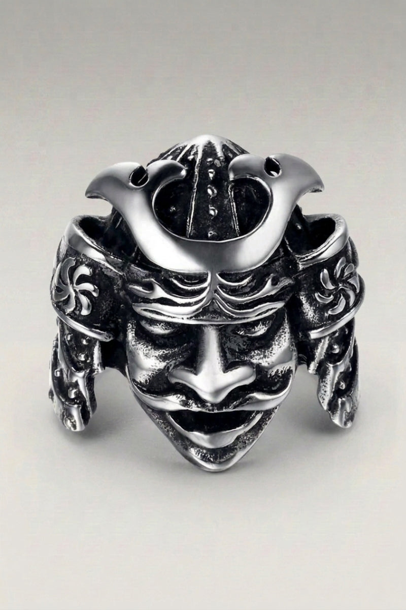 Bague 'Otomail' — casque de guerrier sculpté avec cornes latérales et masque facial sous la visière, photo produit sur fond gris clair