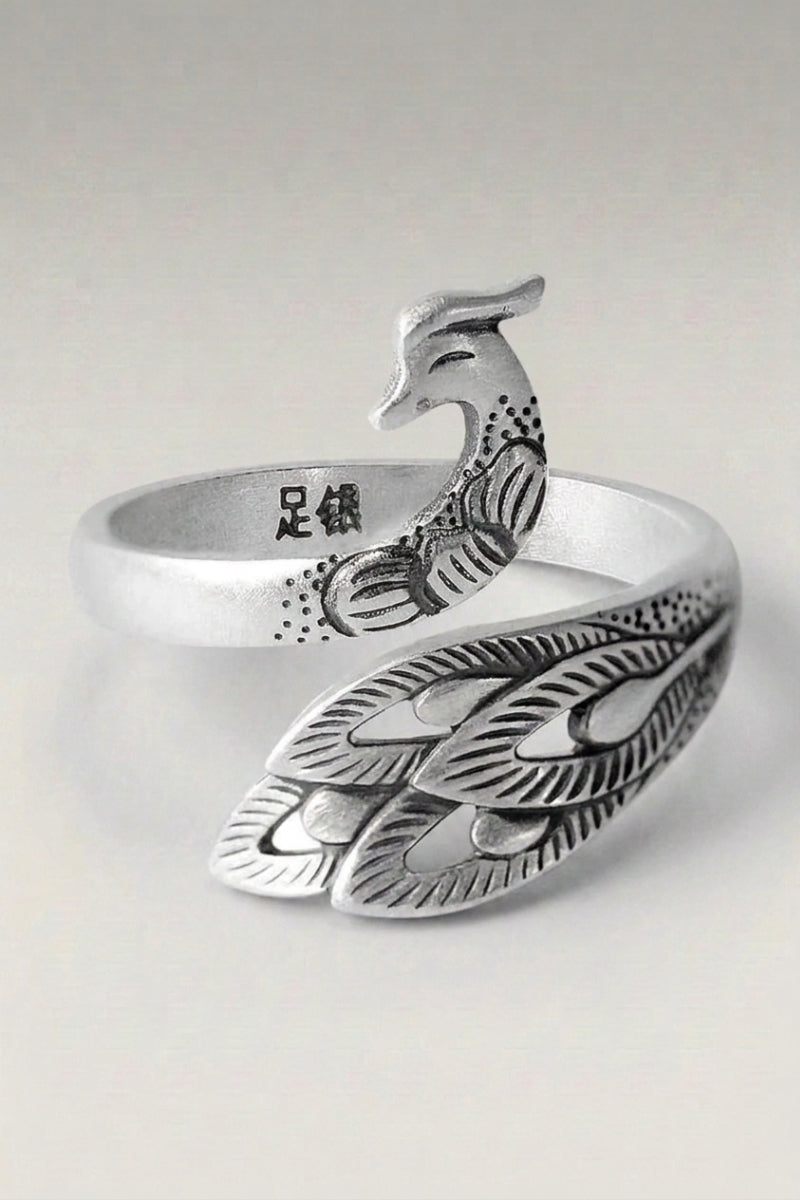 Bague 'Fujiko' — anneau ouvert en forme d'oiseau dont l'aile déployée court le long de l'anneau, photo produit sur fond gris clair