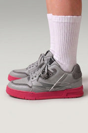 Baskets chunky 'Inazuma' coloris rose — tige blanc et gris posée sur une semelle monochrome vive, portées avec chaussettes blanches sur fond studio gris