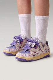 Baskets basses 'Kasumi' coloris violet — graffiti peint sur toute la tige, semelle teintée assortie, portées avec chaussettes blanches sur fond studio gris