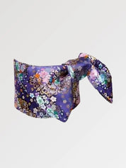 Ceinture obi 'Nadeshiko' nouée sur un buste de mannequin, vue de trois quarts — fond violet profond couvert de fleurs polychromes rehaussées d'or