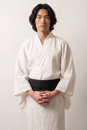 Ceinture obi 'Sapporo' portée à la taille sur un kimono blanc par un mannequin homme — noir profond uni, tissage serré sans motif