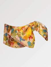 Ceinture obi 'Nanten' nouée sur un buste de mannequin, vue de trois quarts — fond jaune d'or couvert de fleurs multicolores et de motifs éventail