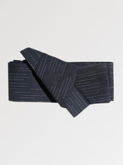 Ceinture obi 'Fukuoka' pliée à plat sur fond gris, extrémités repliées l'une sur l'autre — bleu nuit très sombre à fines rayures verticales ton sur ton