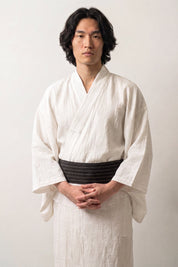 Ceinture obi 'Kyoto' portée à la taille sur un kimono blanc par un mannequin homme — noir à côtes fines et régulières sur toute la largeur