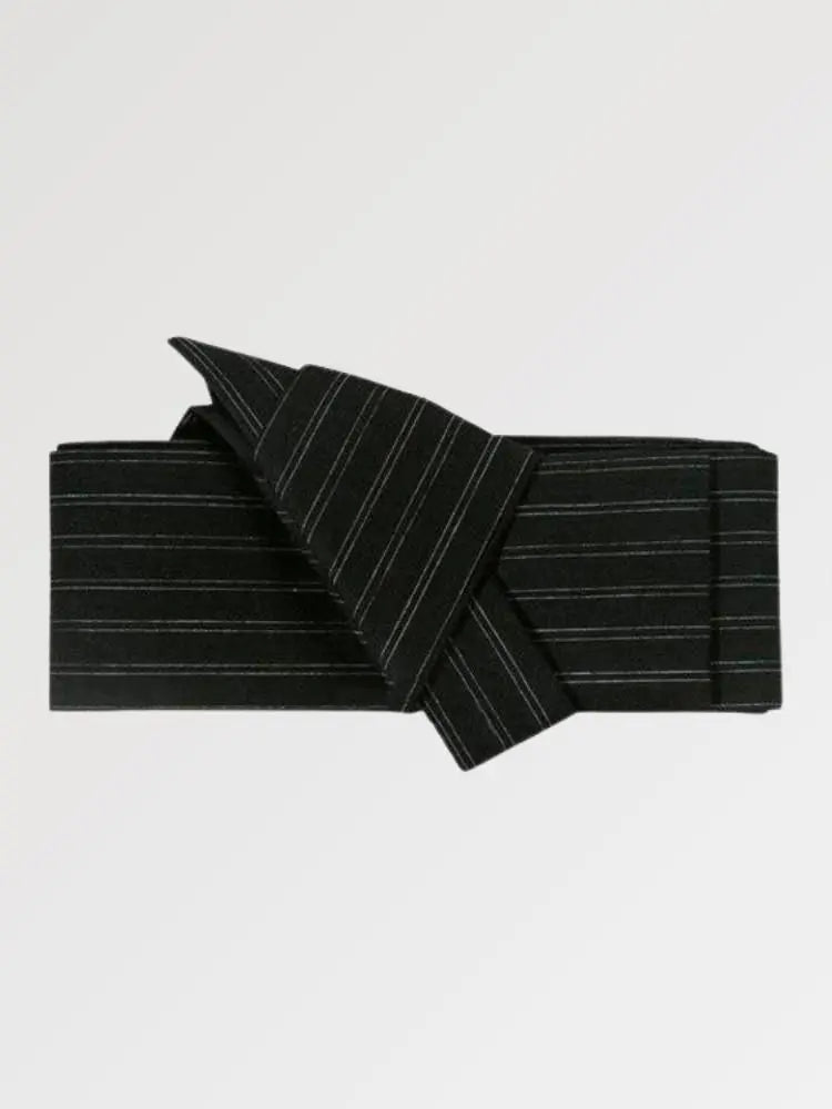 Ceinture obi 'Kyoto' pliée à plat sur fond gris, extrémités repliées l'une sur l'autre — noir à côtes fines et régulières sur toute la largeur