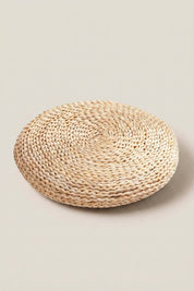 Coussin japonais 'Futon' — zabuton rond en paille tressée à galette épaisse et surface légèrement bombée, paille blonde claire, photo produit sur fond beige