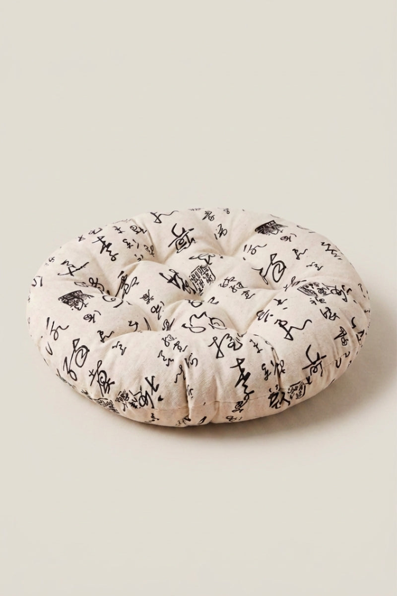 Coussin japonais 'Kiruto' imprimé floral noir sur fond écru — coussin de sol rond capitonné en tissu imprimé, surpiqûres régulières et bord rebondi