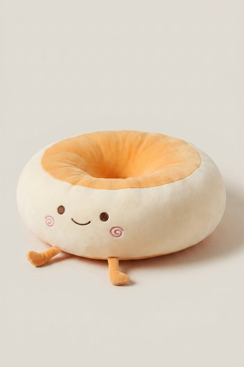 Coussin japonais 'Itami' souriant de trois quarts — coussin de sol en peluche crème en forme de personnage à joues roses, centre orange et petits pieds