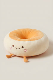 Coussin japonais 'Itami' souriant de trois quarts — coussin de sol en peluche crème en forme de personnage à joues roses, centre orange et petits pieds