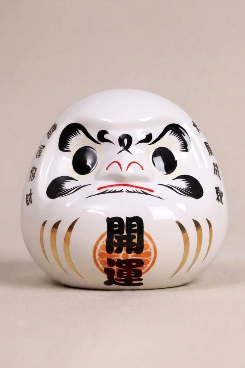 Daruma blanc en céramique posé sur fond beige — figurine ronde de 11 cm au kanji 神, yeux vierges pour le rite du vœu