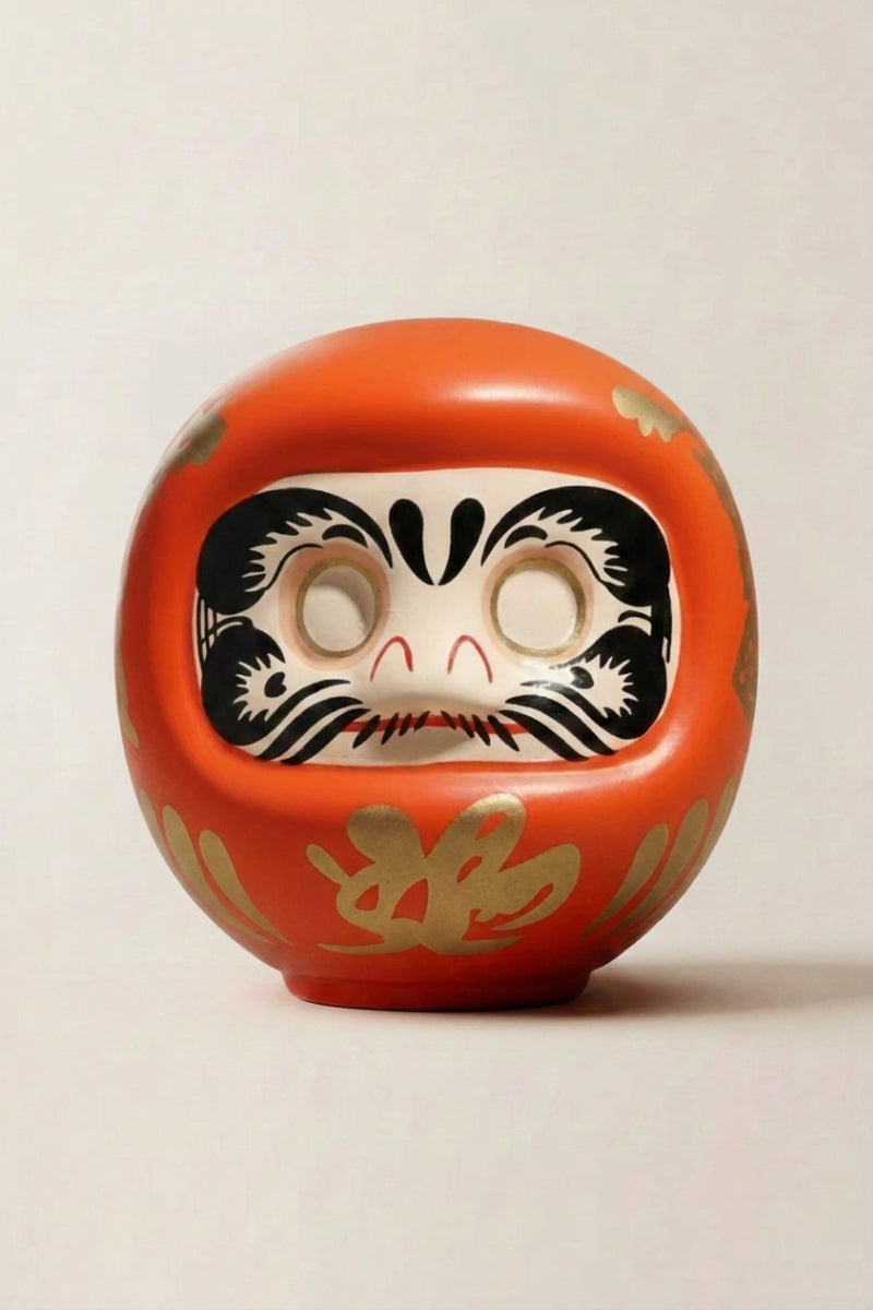 Daruma orange en céramique posé sur fond beige — figurine ronde de 11 cm au kanji 開運, yeux vierges pour le rite du vœu