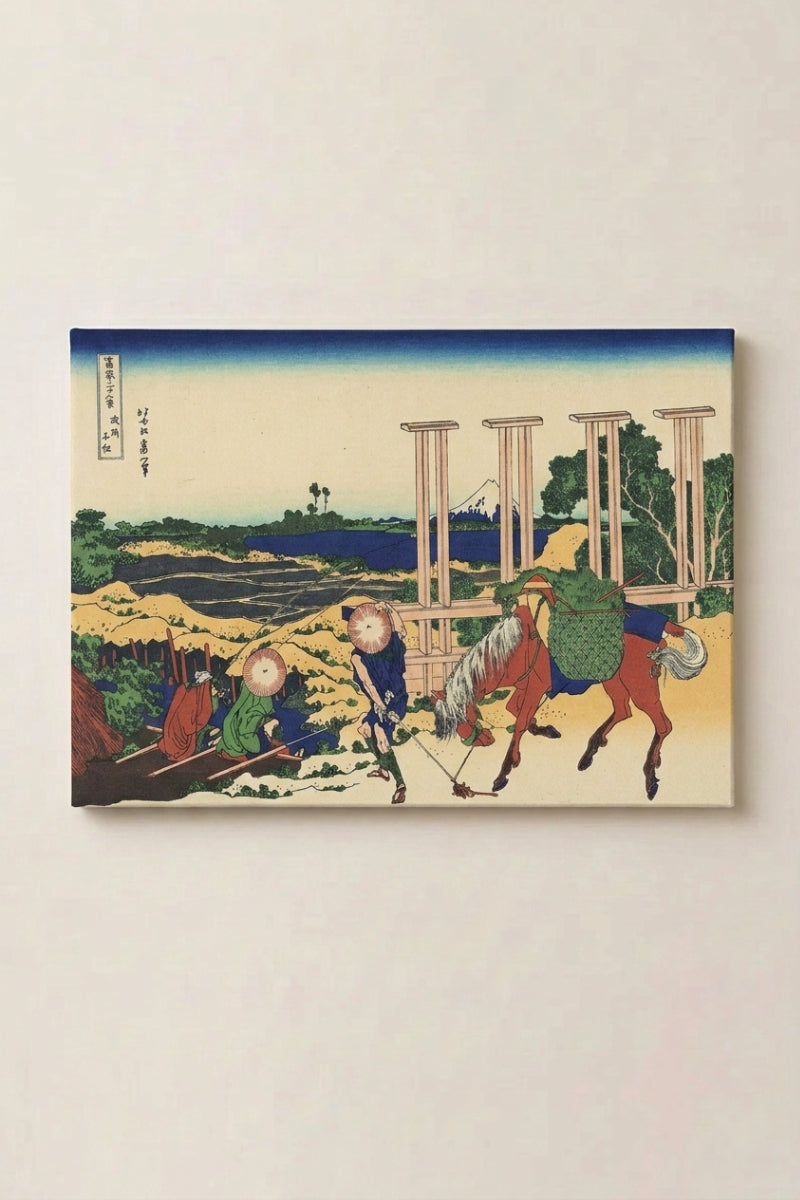 Estampe japonaise 'Umakishi' en panneau encadré sur mur beige — chevaux menés par des palefreniers devant une structure de bois, mont Fuji au second plan
