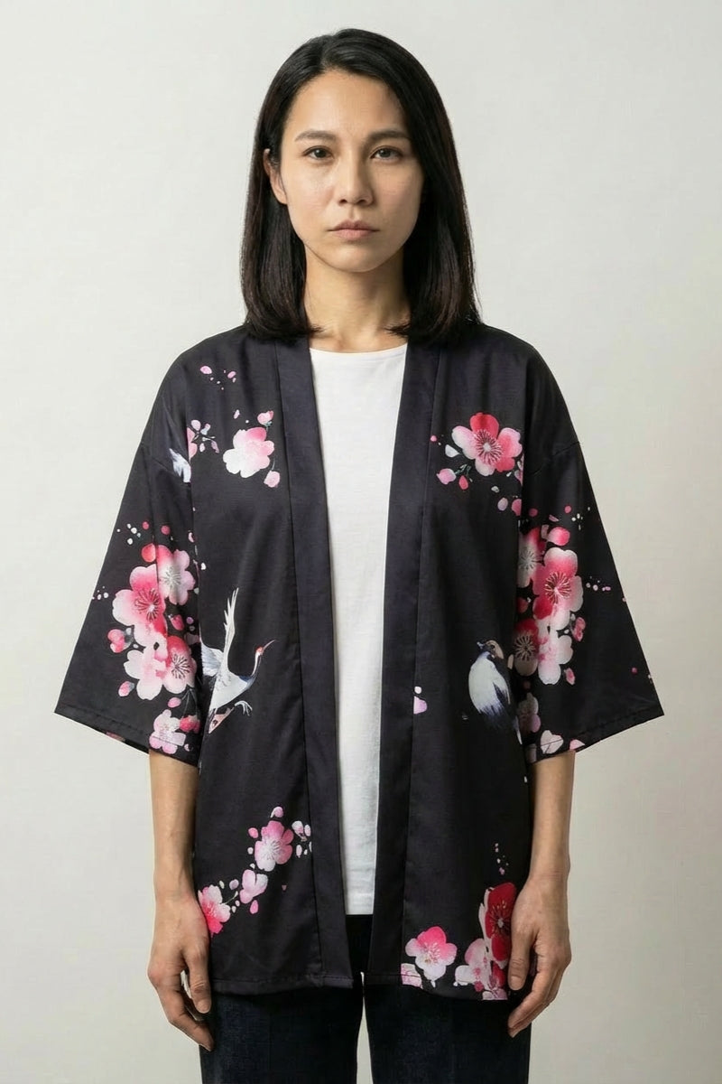 Cardigan kimono femme Sakura x Geiko noir, imprimé d'une geisha sous les cerisiers roses et une grue, porté ouvert - Japanstreet