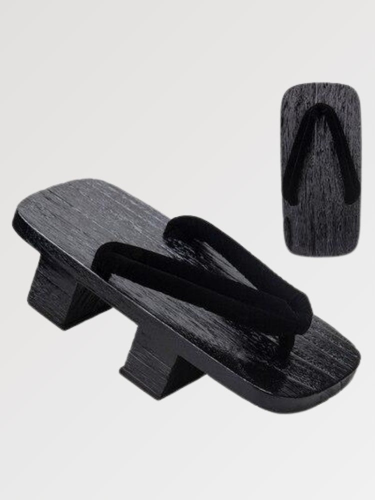 Paire de geta 'Hekinan' vue de trois quarts — socle en bois noirci à deux dents, lanière noire mate assortie au socle, dessous visible