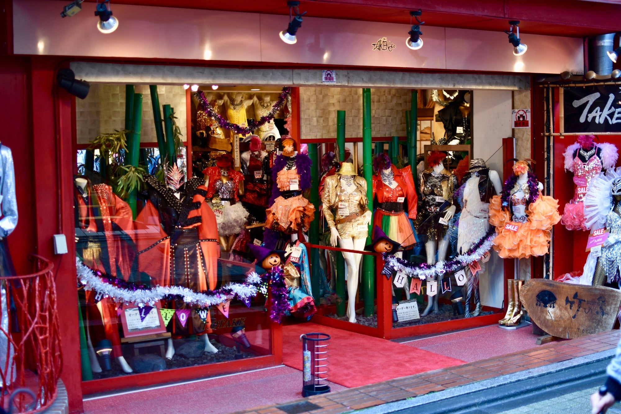 Vitrine d’une boutique colorée à Harajuku exposant des costumes excentriques et vêtements de mode japonaise inspirés de la pop culture.