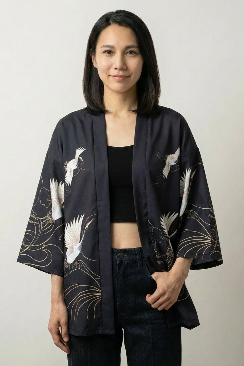 Veste kimono femme Setsuko noire, imprimé de grues blanches et fils dorés, portée ouverte - Japanstreet
