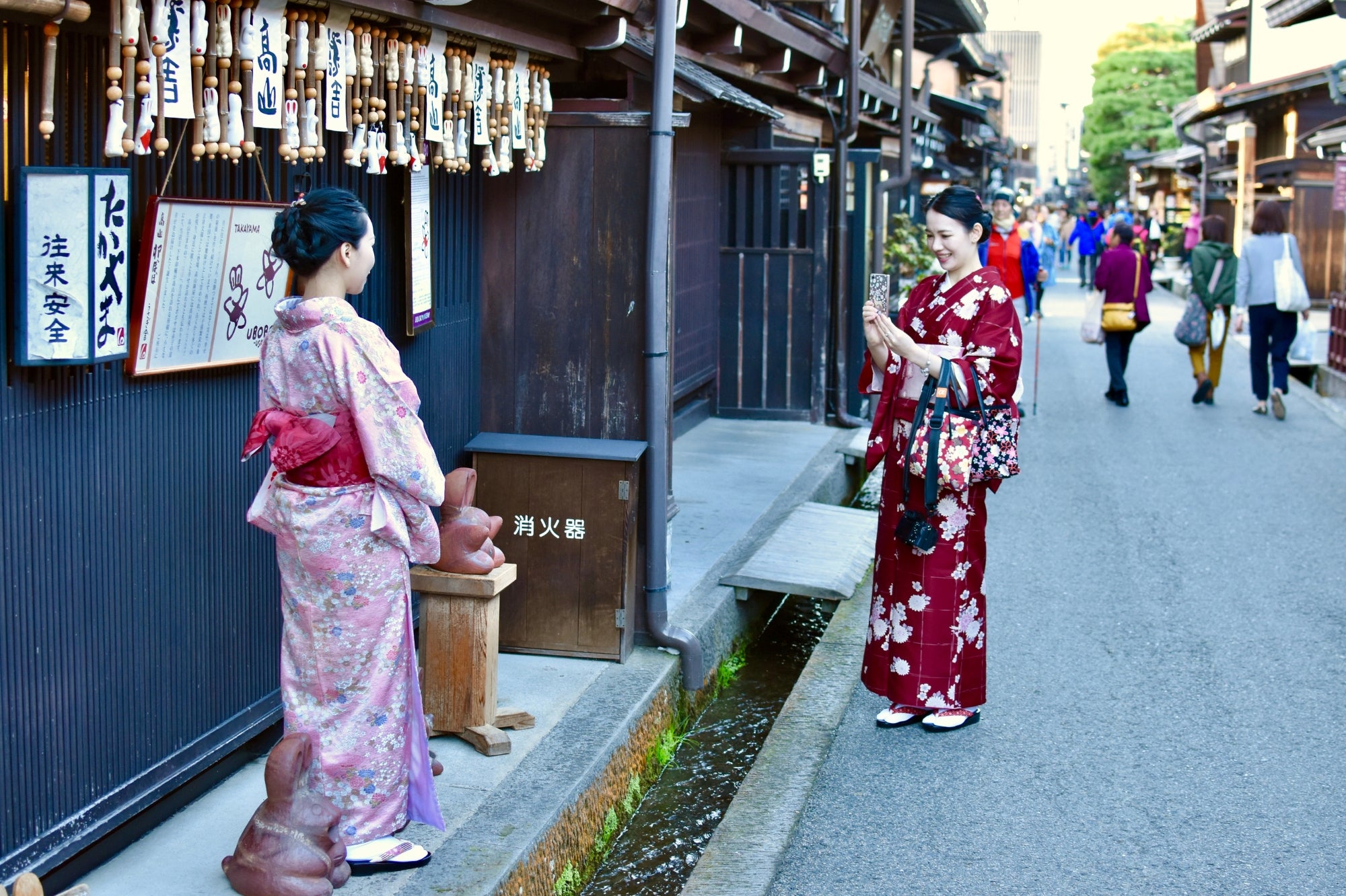 Deux femmes en kimono se prennent en photo dans une rue traditionnelle du quartier de Gion à Kyoto, au cœur de la culture japonaise.