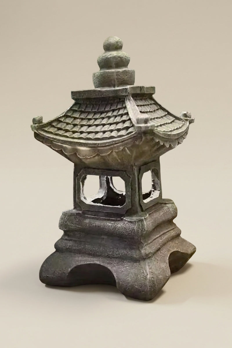 Lanterne japonaise — lanterne traditionnelle bronze à toits superposés et corps ajouré, socle massif en arcades, photo produit sur fond beige uni