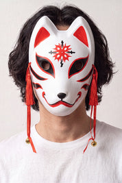 Masque kitsune à l'étoile porté par un mannequin sur fond clair — renard blanc orné d'une étoile rouge au front, traits fins et cordons rouges