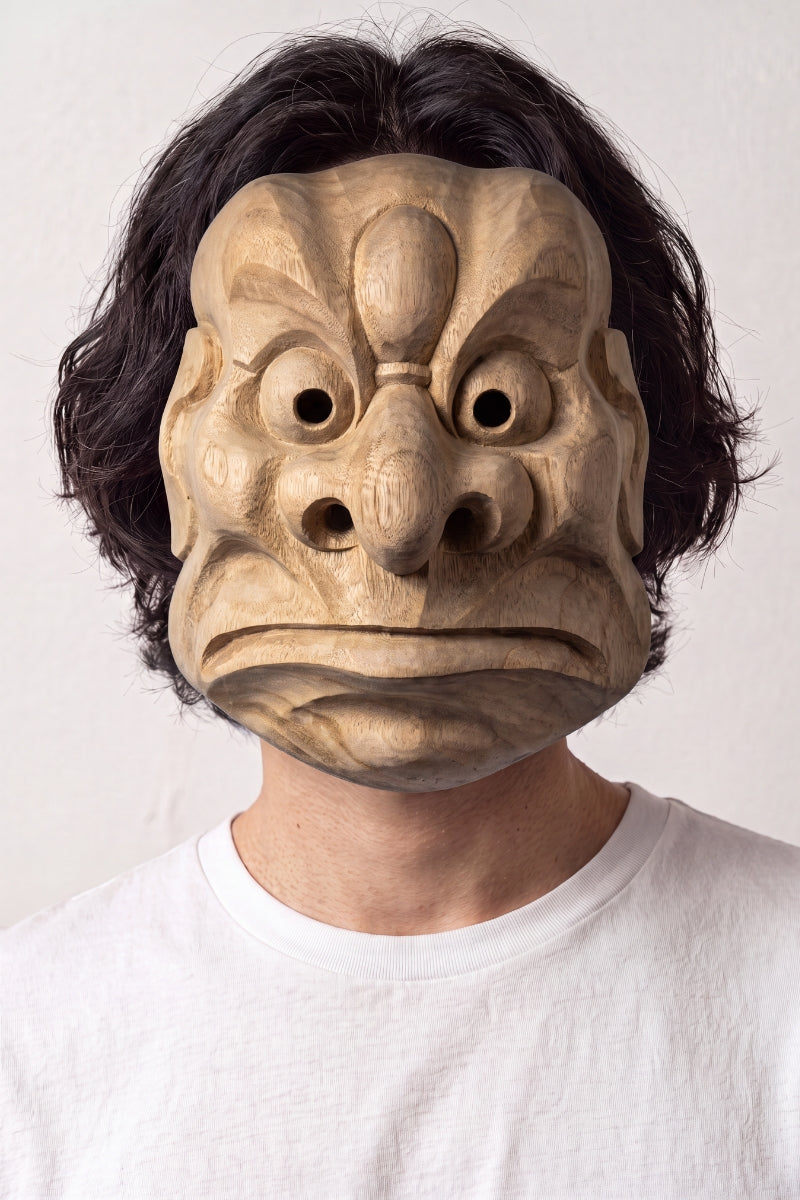 Masque tengu karasu porté par un mannequin sur fond clair — tengu corbeau sculpté au bec proéminent, gros yeux ronds et front nervuré