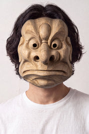 Masque tengu karasu porté par un mannequin sur fond clair — tengu corbeau sculpté au bec proéminent, gros yeux ronds et front nervuré