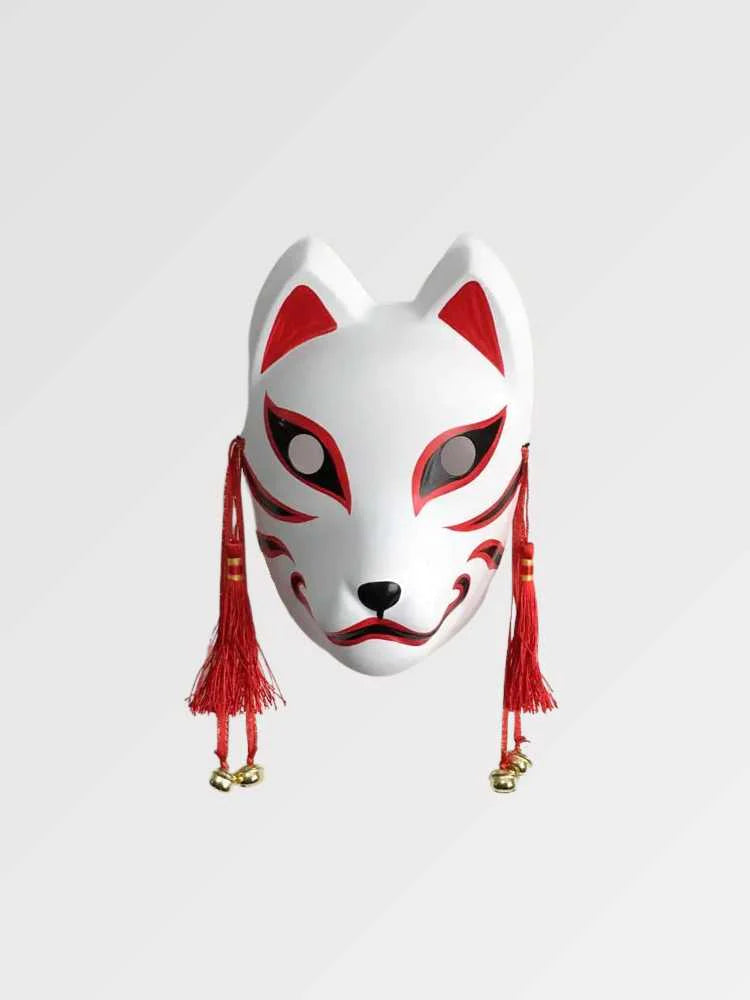 Masque kitsune rouge et blanc présenté de face sur fond gris uni — renard blanc à traits rouges, pompons rouges et grelots dorés sur les côtés