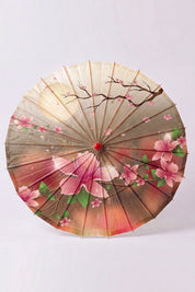Ombrelle japonaise 'Chisana' vue de dessus, ouverte à plat — petite toile en dégradé brun et rose à fleurs de cerisier, baleines rayonnant depuis le moyeu