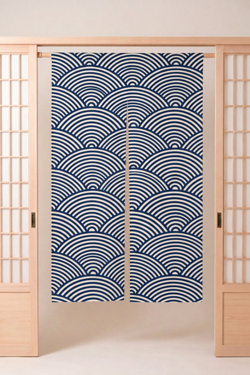 Noren japonais 'Jikan' suspendu à une porte en bois clair — éventails de vagues seigaiha bleu marine emboîtés en arcs concentriques sur fond clair