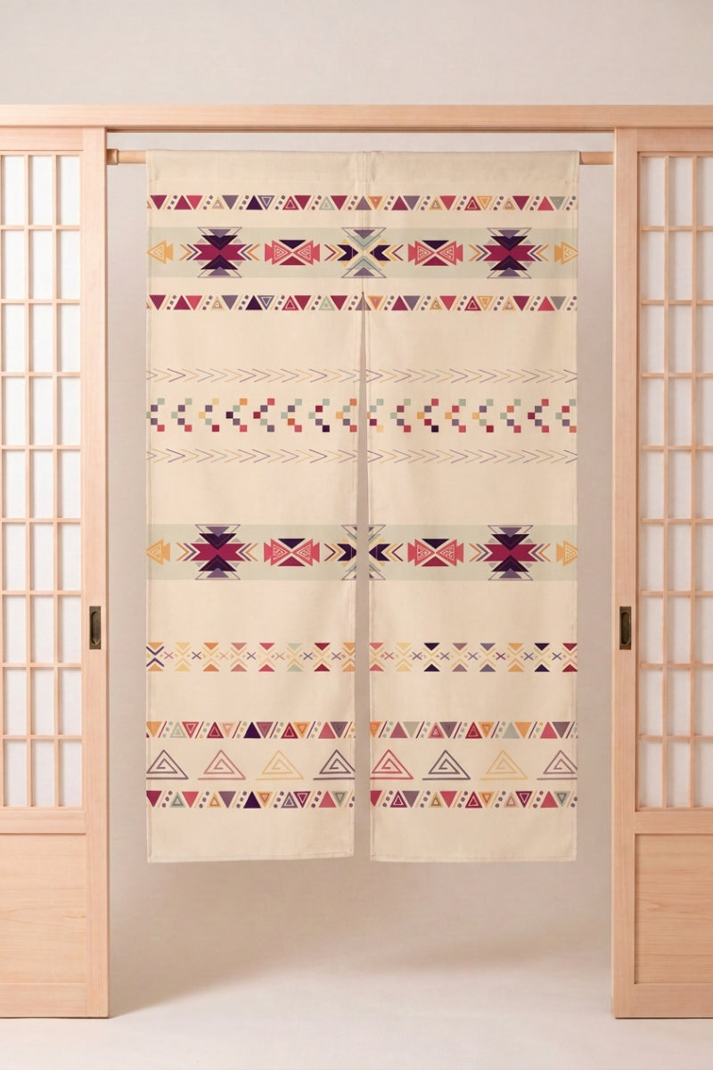 Noren japonais 'Hibiki' suspendu dans l'encadrement d'une porte en bois clair — bandes géométriques rose, ocre et noir sur fond écru, motif tissé façon kilim