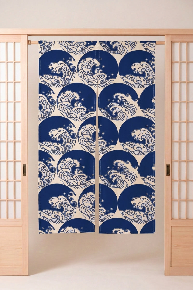Noren japonais 'Yasumi' suspendu à une porte en bois clair — crêtes d'écume blanches sur fond bleu profond, vagues stylisées en bandes horizontales