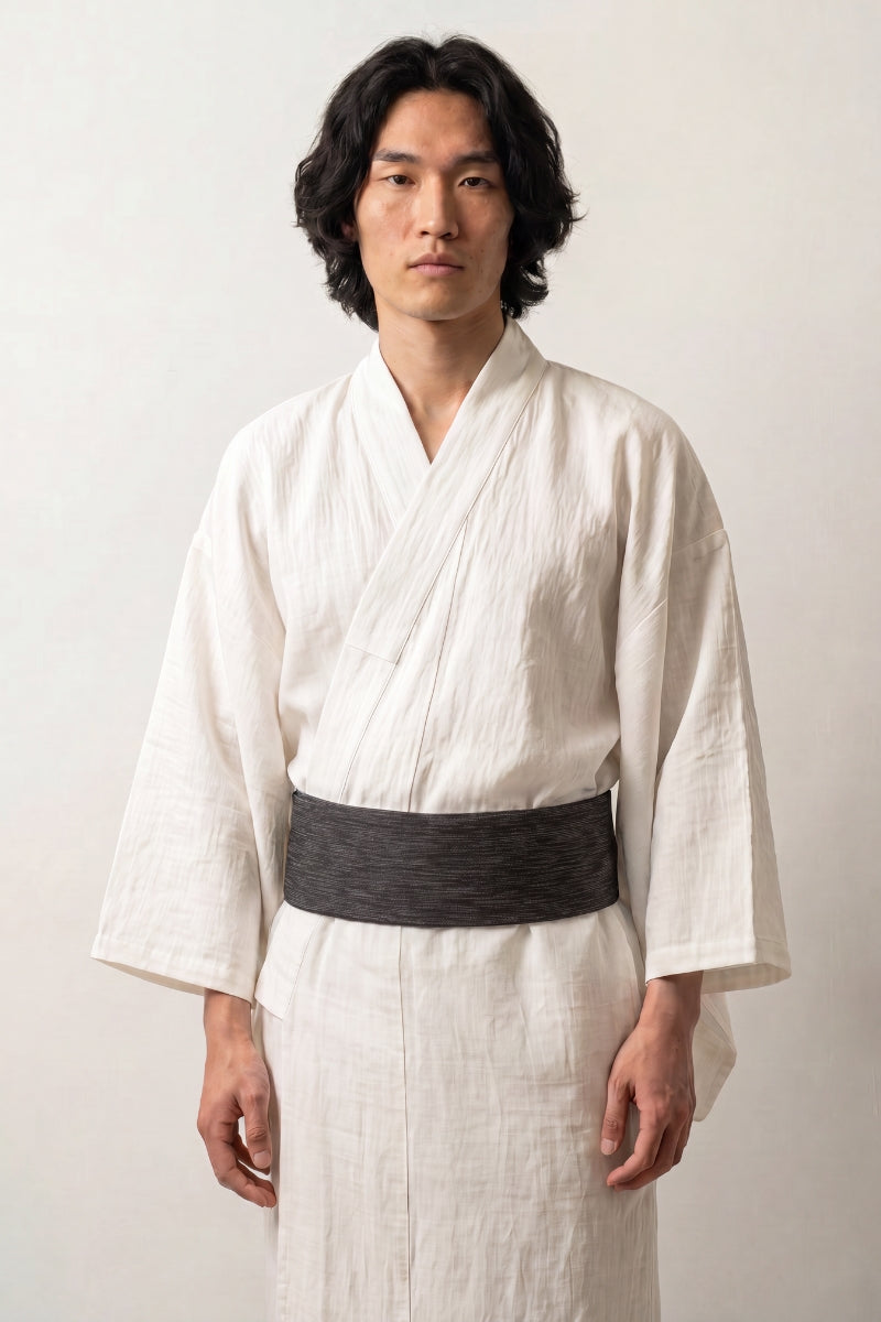 Ceinture obi 'Nagoya' portée à la taille sur un kimono blanc par un mannequin homme — noir strié de lignes horizontales irrégulières plus claires