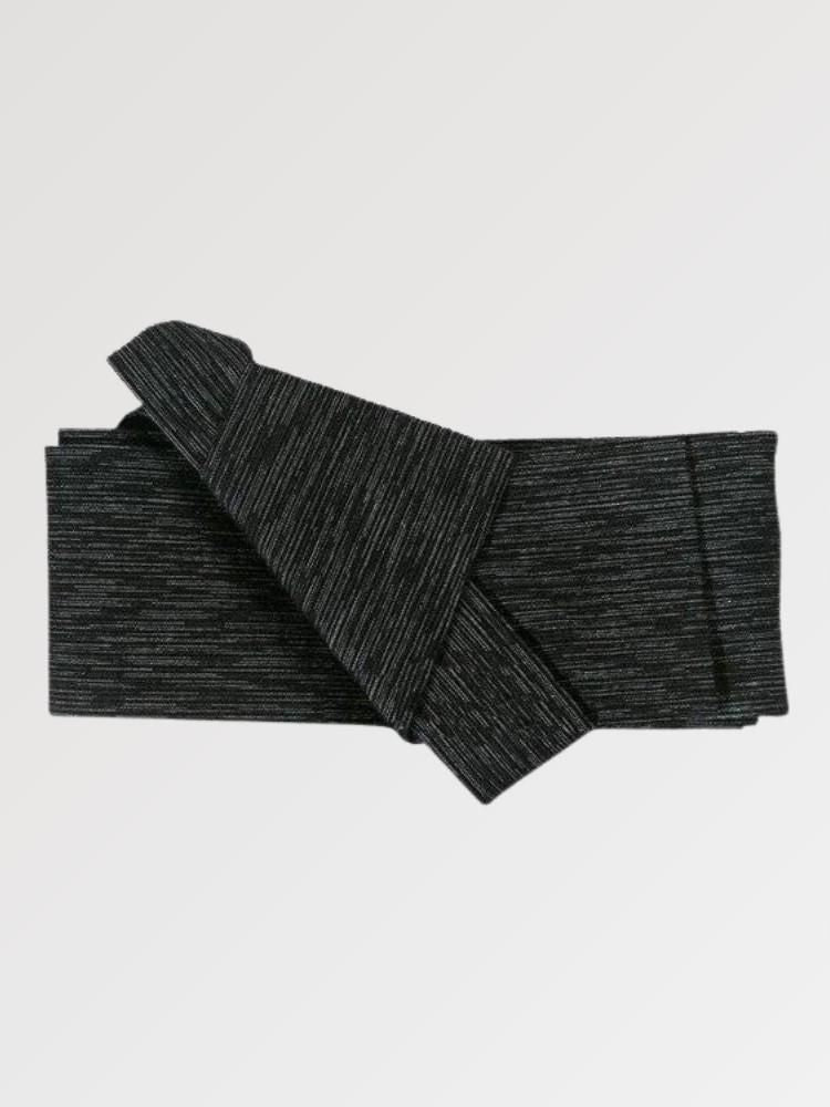 Ceinture obi 'Nagoya' pliée à plat sur fond gris, extrémités repliées l'une sur l'autre — noir strié de lignes horizontales irrégulières plus claires