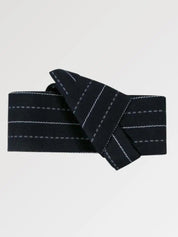 Ceinture obi 'Nagano' pliée à plat sur fond gris, extrémités repliées l'une sur l'autre — fond bleu nuit parcouru de fines rayures blanches en pointillé