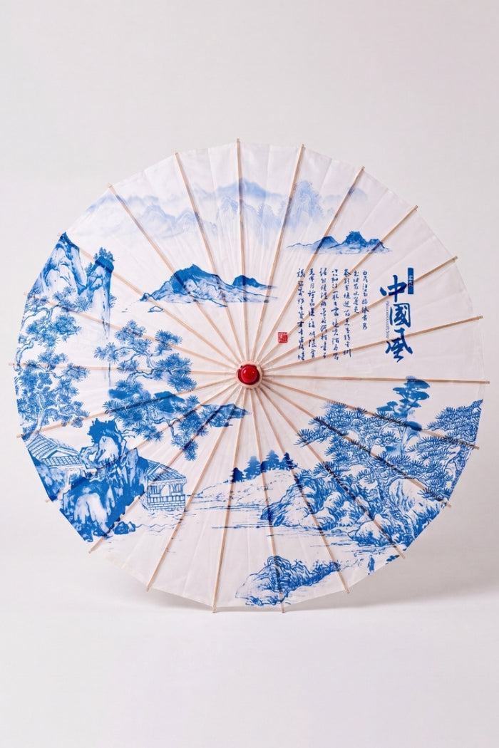 Ombrelle japonaise 'Kashika' vue de dessus, ouverte à plat — toile blanche à motif de jardin bleu, feuillages et pavillons, baleines rayonnant depuis le moyeu