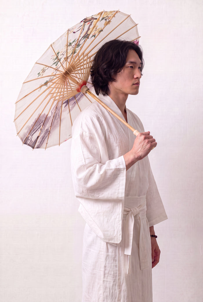 Ombrelle japonaise 'No-Kodai' ouverte et tenue par un mannequin en kimono blanc — toile crème à branche fleurie rose peinte en réserve