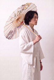 Ombrelle japonaise 'No-Kodai' ouverte et tenue par un mannequin en kimono blanc — toile crème à branche fleurie rose peinte en réserve