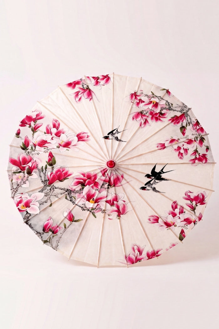Ombrelle japonaise 'Nomikomu' vue de dessus, ouverte à plat — toile crème couverte de fleurs de cerisier roses, baleines rayonnant depuis le moyeu