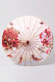 Ombrelle japonaise 'Blossom' vue de dessus, ouverte à plat — toile blanche à branches de cerisier roses courant vers le centre