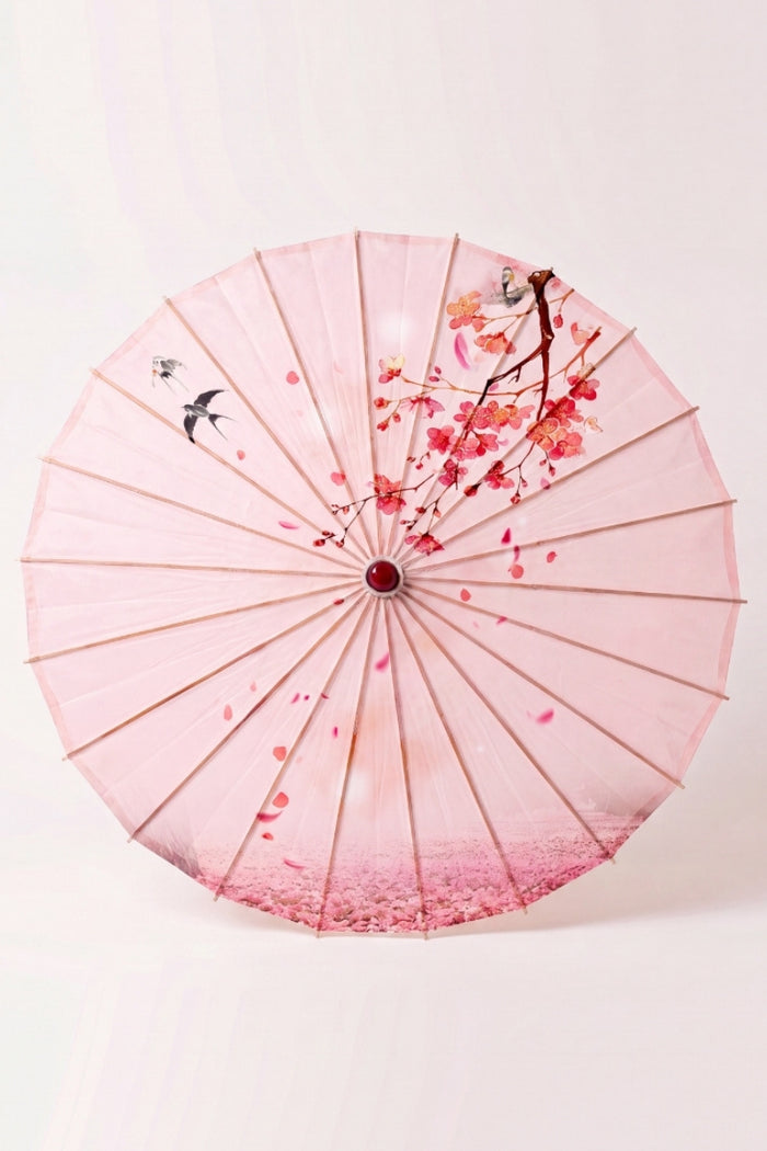 Ombrelle japonaise 'Sakura Classic' vue de dessus, ouverte à plat — toile rose pâle à oiseaux et fines branches fleuries, baleines rayonnant depuis le moyeu