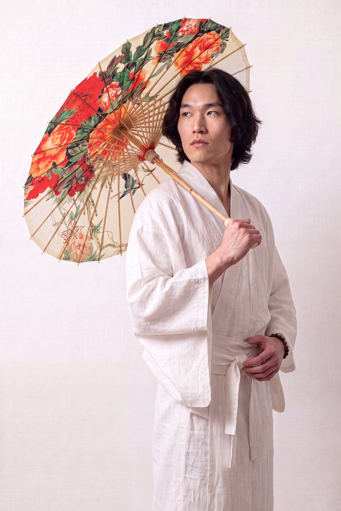 Ombrelle japonaise 'Asatsuyu' ouverte et tenue par un mannequin en kimono blanc — toile crème à grandes fleurs orange et rouges